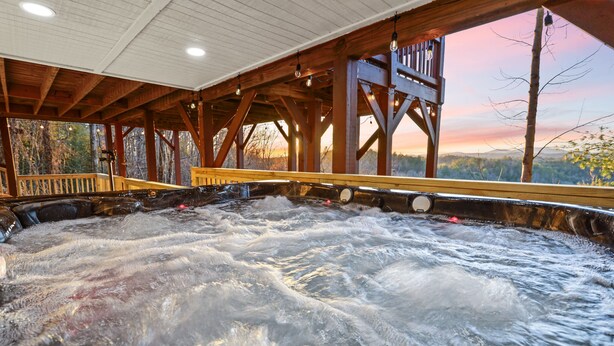 A hot tub with a wooden deck and a view of the surrounding forest. - Mountain view cabin near Ellijay w/ hot tub! (Gilmer County)