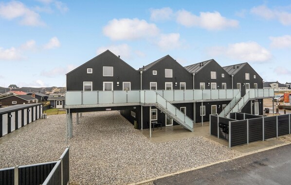 Een gebouw met een modern ontwerp, met een overdekte doorgang en een trap die naar een hoger gelegen niveau leidt.