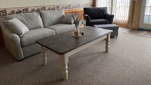 A living room with a sofa, armchair, and coffee table. - SPRING GETAWAY! Comfortable 2BR cozy cottage just a few steps from Sandusky Bay! (Sandusky)