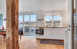 Enjoy meals in the spacious kitchen with a large island, oven, and stovetop, plus a dining area with a table and chairs.