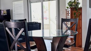 A dining area with a glass-top table surrounded by dark wooden chairs with metal frames. - No Minimum Stay! No Chores! Kids allowed (Port O'Connor)