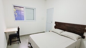 A bedroom with a bed, a desk, and a chair. - Pampering Suites (São Paulo)