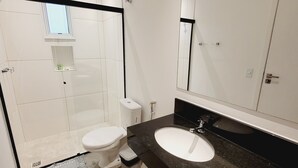 A modern bathroom with a large mirror, a bathtub, and a toilet. - Pampering Suites (São Paulo)