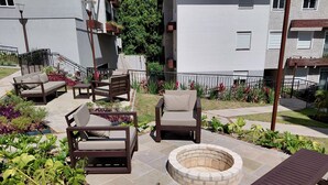 A patio area with outdoor furniture, a fire pit, and a garden with various plants. - Top apartment, 4 minutes from the covered street by car, kids' area, heated pool, gym. (Gramado)