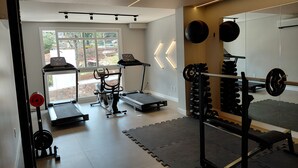 A home gym with exercise equipment, including a treadmill, stationary bike, and weightlifting station. - Top apartment, 4 minutes from the covered street by car, kids' area, heated pool, gym. (Gramado)