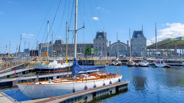 A harbor with boats docked, a bridge, and a large building in the background. - Amazing apartment in Oostende with WiFi (Oostende)