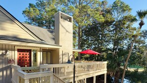 Un immeuble de deux étages doté d’un balcon, d’une porte rouge et d’une enseigne indiquant « Beachwalk 197 ».
