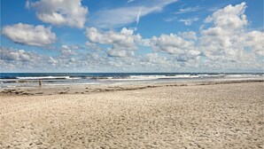 A wide sandy beach with waves and a clear sky. - Cozy home in Nexø with house sea view (Nexø)