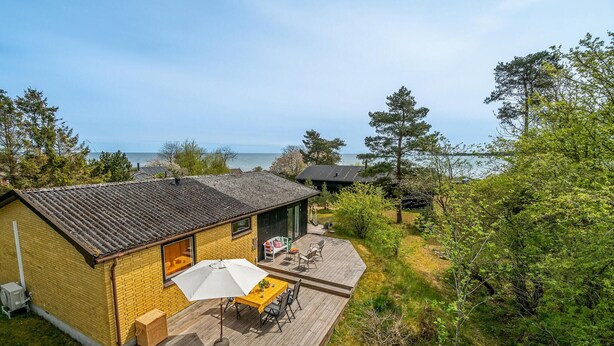 A single-story building with a patio area, a small deck, and a view of the sea. - Cozy home in Nexø with house sea view (Nexø)