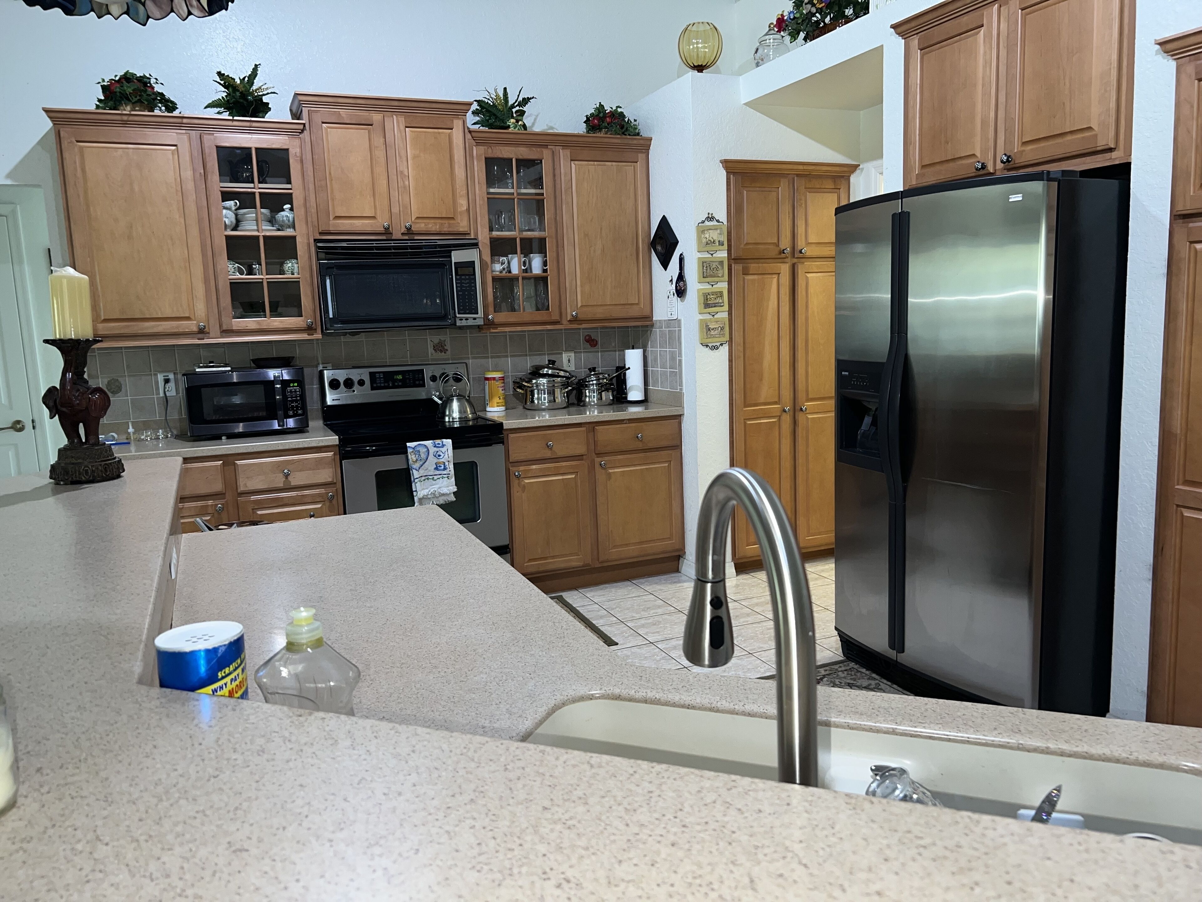 A kitchen with wooden cabinets, stainless steel appliances, and a granite countertop.