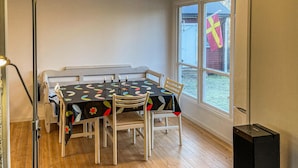 Ein Eckzimmer mit Tisch, Stühlen, einem Fenster und einem Lautsprecher.