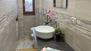 A modern bathroom with a large white sink, a mirror, and a potted plant. - Bnbook Studio Beatrice Rho Fiera (Rho)
