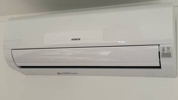 A white wall-mounted air conditioning unit with the brand name "HITACHI" visible.