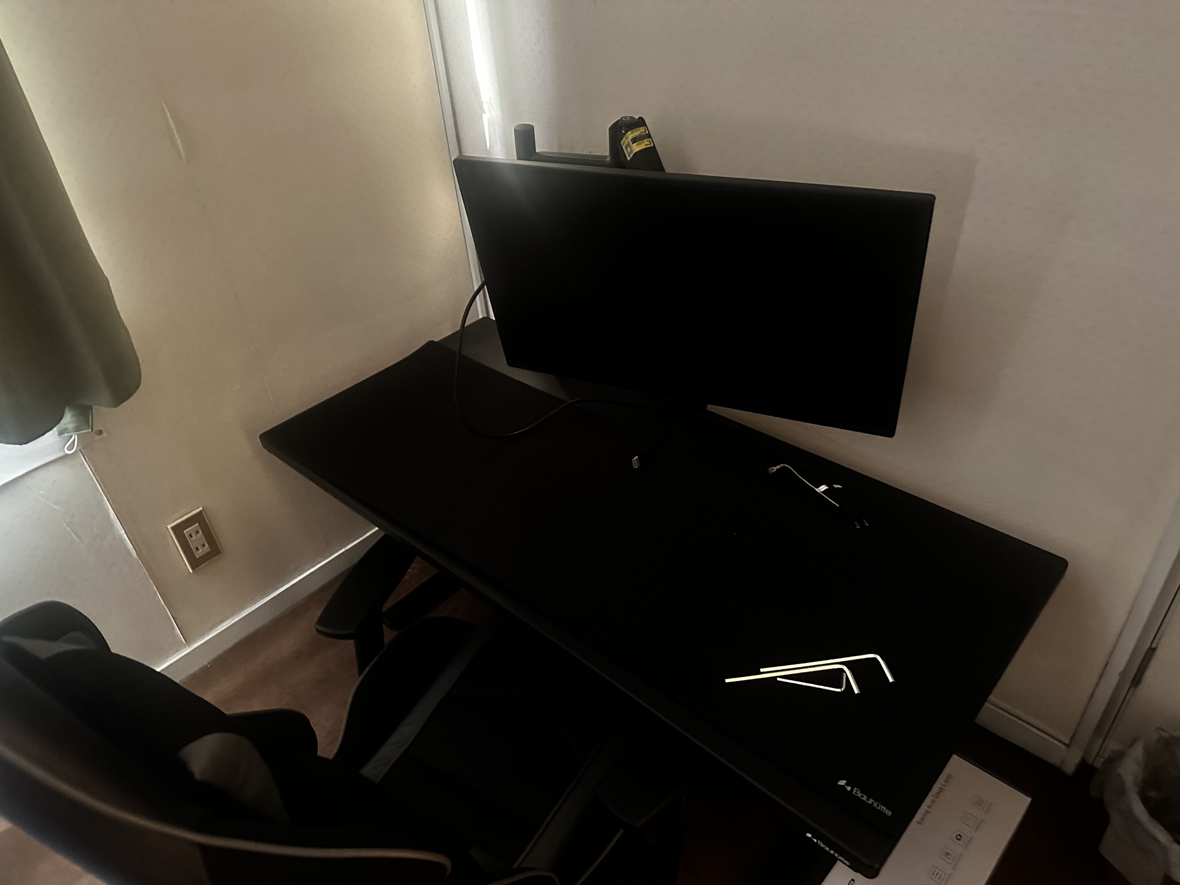 A black desk with a flat-screen TV, a keyboard, and a mouse.