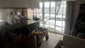 A kitchen with a large window, a fan, and a view of the sea. - Pension Lakeside (Otsu)