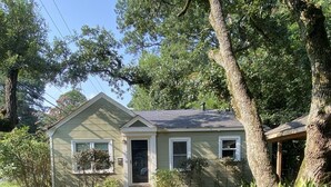 A single-story house with a front porch, a small garden, and a gravel driveway.