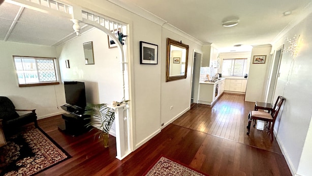 A spacious living area with hardwood floors, a dining area, and a kitchen.