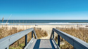 A wooden boardwalk leading to a beach with clear skies. - Luxury Beachfront Studio, Endless Ocean Views, Resort Amenities, Newly Remodeled (Myrtle Beach)