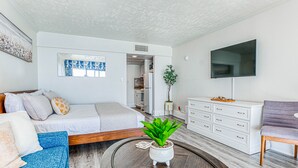 A modern living room with a bed, sofa, coffee table, and TV. - Luxury Beachfront Studio, Endless Ocean Views, Resort Amenities, Newly Remodeled (Myrtle Beach)