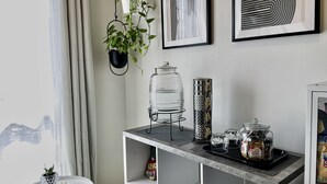 Una sala de estar moderna con una mesa de centro de mármol, una planta colgante y obras de arte enmarcadas en la pared.