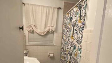 Une petite salle de bain avec des toilettes, un lavabo et un rideau de douche.