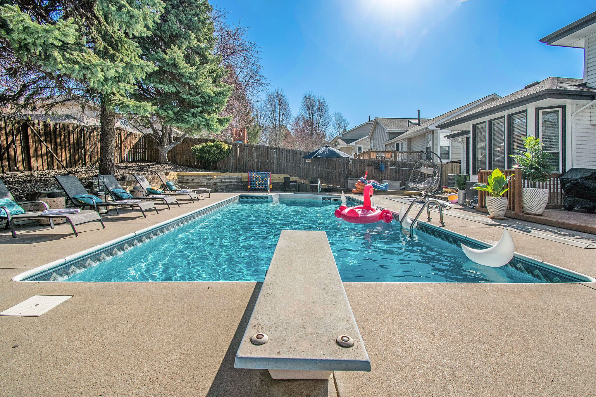 A swimming pool with lounge chairs and a floating ring.