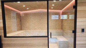 Un spa moderno con paneles de madera, una pared de vidrio y una zona de hidromasaje visible.