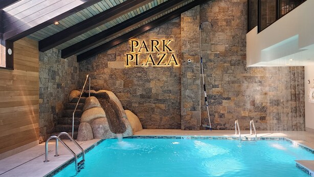 Una piscina interior con una pared de piedra y un cartel que dice "PARK PLAZA".