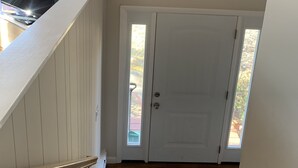 A staircase leading to a door with a view of a garden. - Spacious & sunny, 7 minutes from the beach! (Old Orchard Beach)