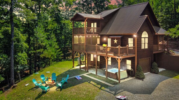 Une cabane en bois à deux étages, dotée d’un balcon et entourée d’une forêt.
