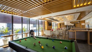 A pool table in a modern indoor setting with large windows and a dining area. - Best Western Plus Chandigarh Mohali. (Mohali)