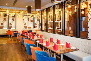 Um restaurante com uma ampla área de refeições, várias mesas e cadeiras.