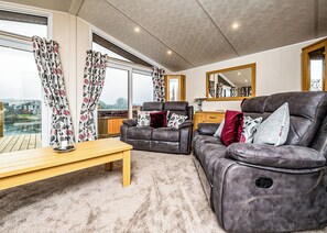 A living room with a sofa, armchair, and table.