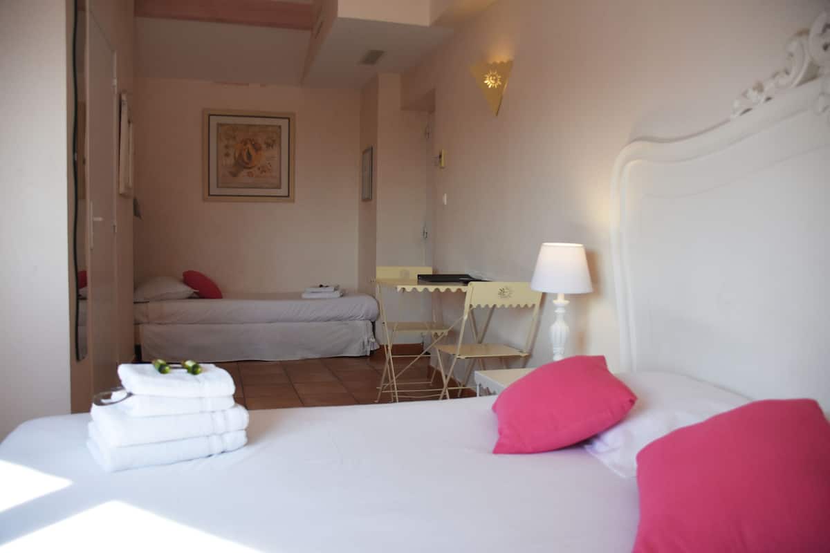 Ein Hotelzimmer mit einem Bett, einem Schreibtisch, einem Stuhl und einer Lampe.