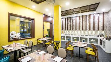 A restaurant with yellow walls, multiple dining tables, and chairs.