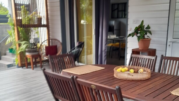A wooden dining table with chairs, a clock, and a potted plant.