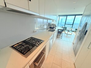 Una cocina moderna con estufa a gas, horno y un amplio ventanal con vistas a la ciudad.