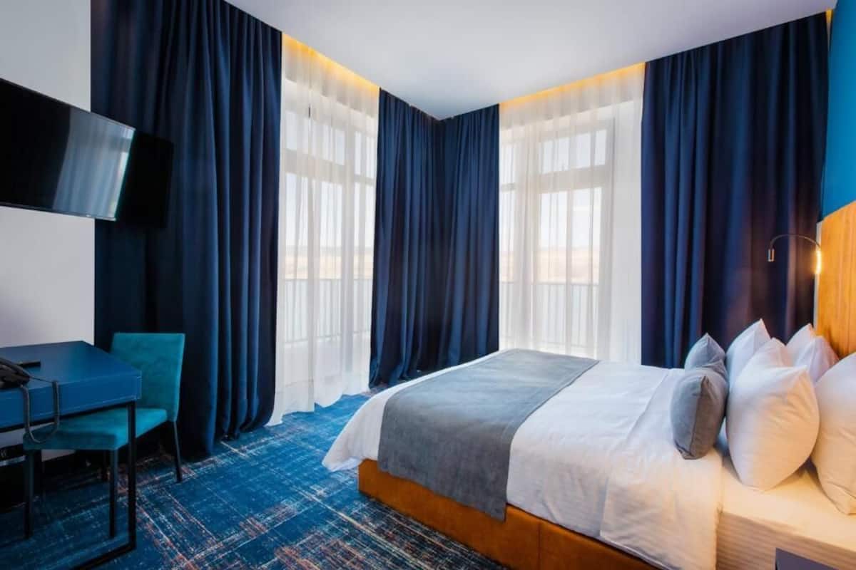 Une chambre d’hôtel avec un lit, un bureau et une télévision.
