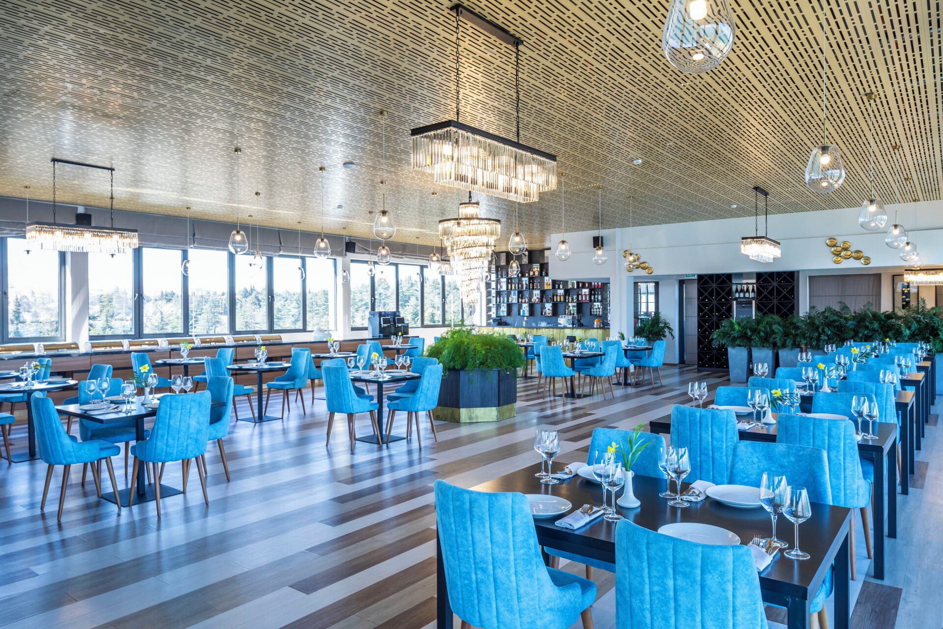 Ein großzügiges Restaurant mit hohen Decken, großen Fenstern und moderner Beleuchtung.