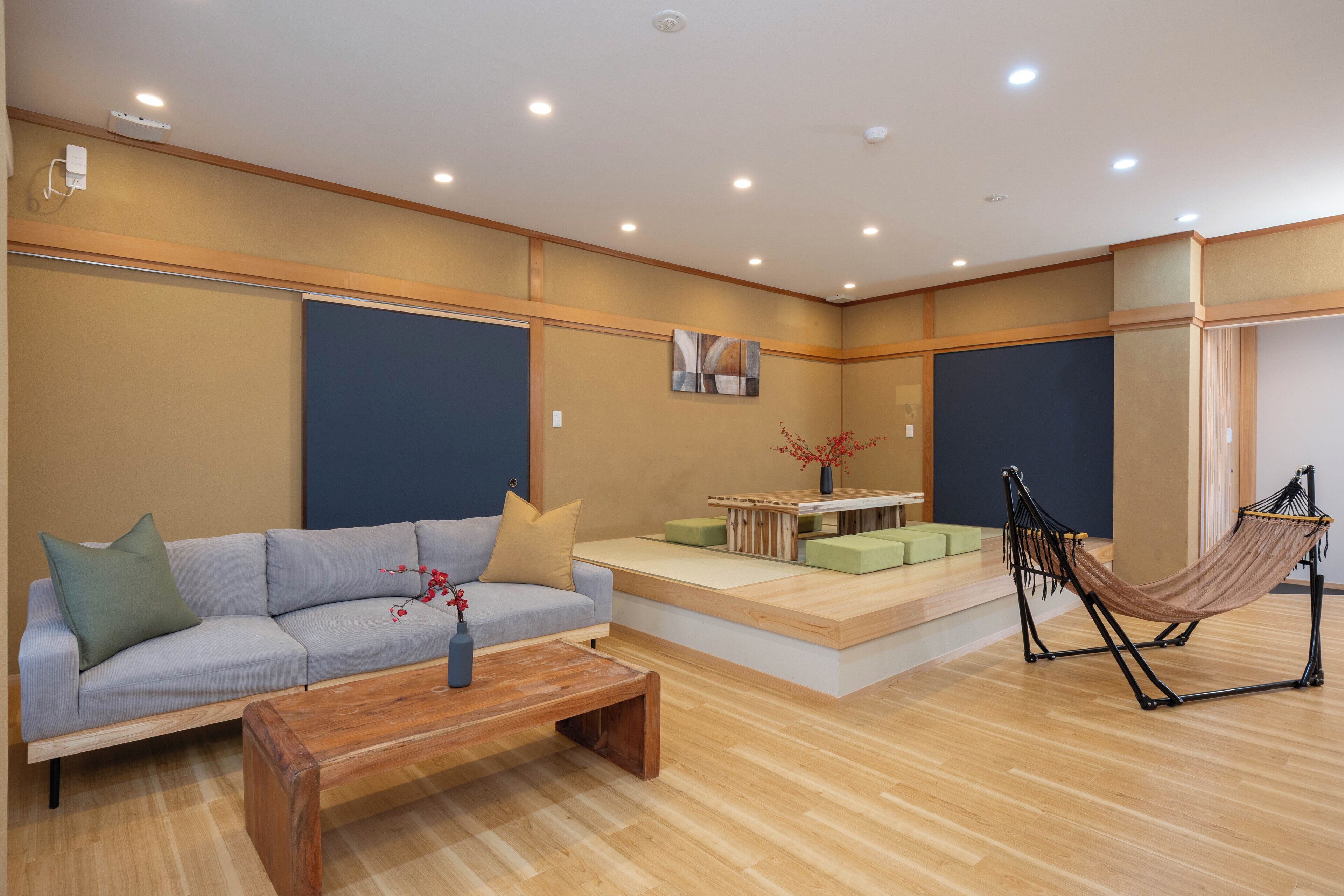 A modern living room with a sofa, coffee table, and a hammock.