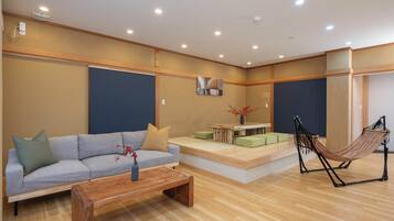 A modern living room with a sofa, coffee table, and a hammock.