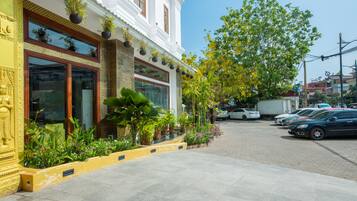 Traditional hotel facade with a welcoming entrance and lush greenery.
