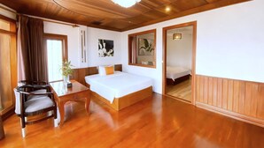 Una habitación de hotel con techo de madera, una cama, un escritorio y una silla.