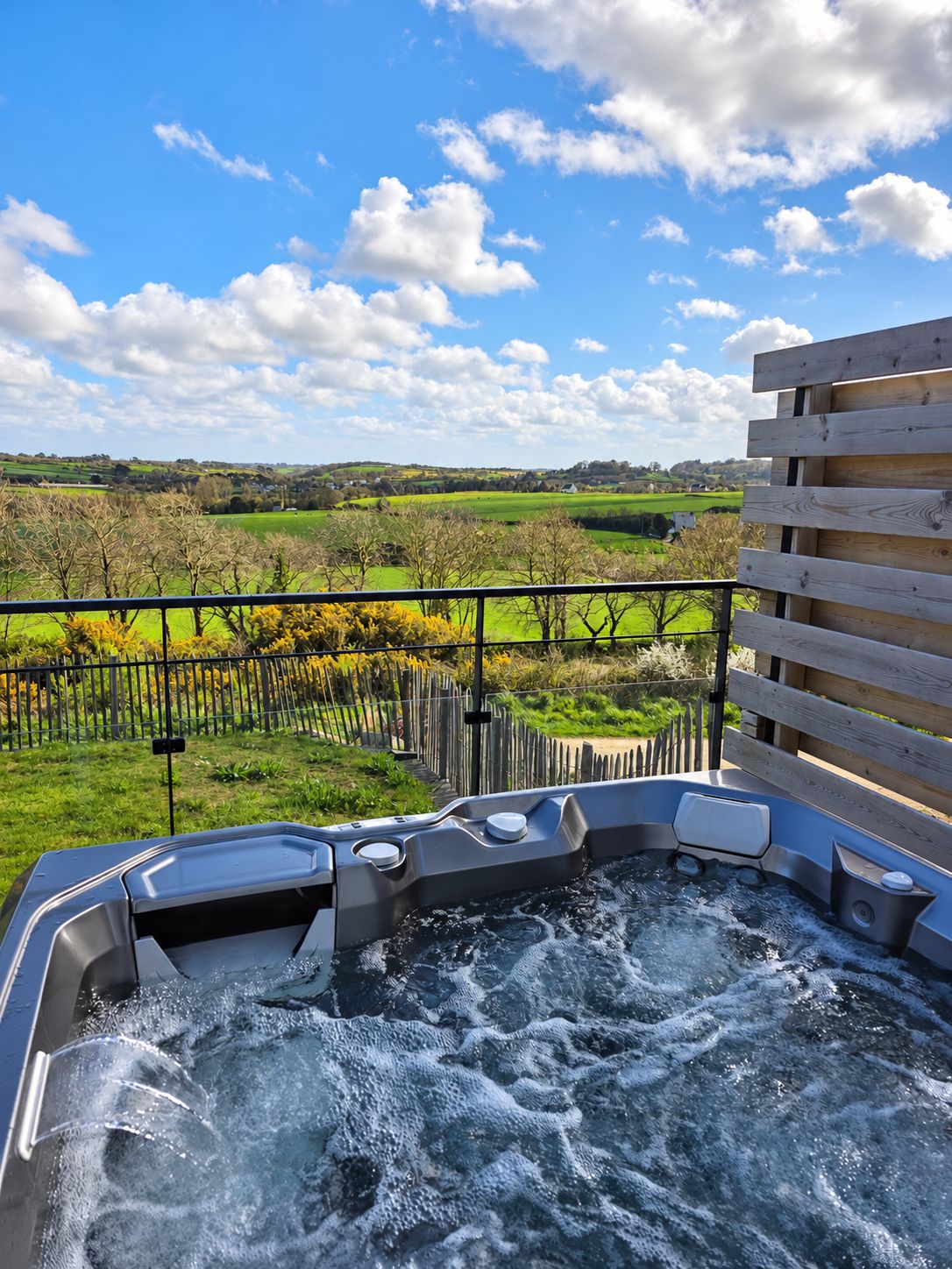 A hot tub with a view of a rural landscape.