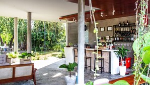 An outdoor patio area with a bar, seating, and potted plants. - Kampot Tropical Village (Kampot)