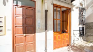 A building with a wooden door and a window. - Flower Apartment (Cefalù)