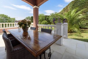 Enjoy al fresco dining on this serene patio surrounded by lush greenery and a beautiful hillside view.