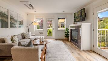 Ein modernes Wohnzimmer mit Sofa, Couchtisch und Kamin.