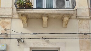 A building with a white door, a balcony with plants, and a window. - Fortuna Guest House (Syracuse)