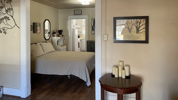 A bedroom with a bed, a dresser, a mirror, and a framed quote on the wall.